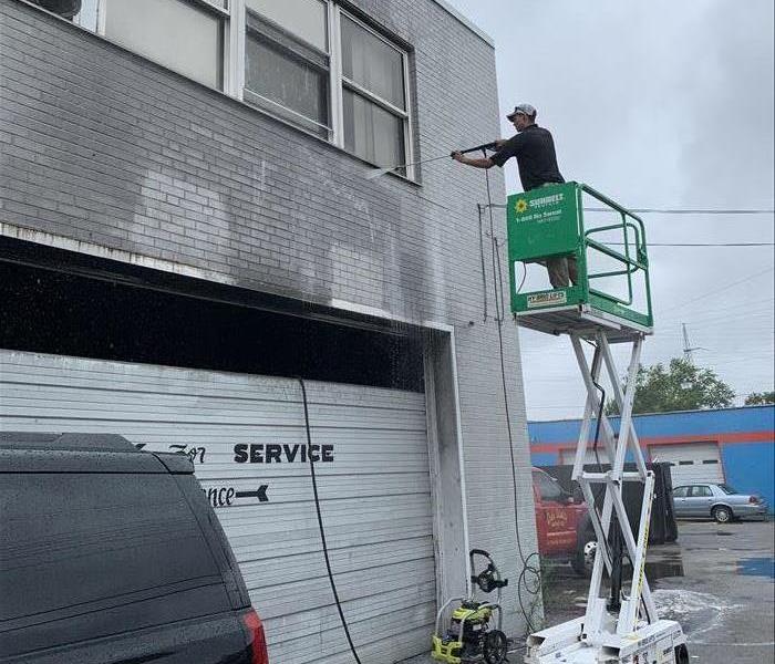 Front of commercial building that is covered in soot