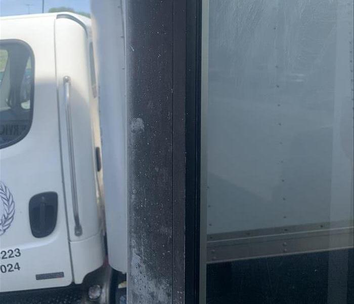 Metal framed door at an automotive shop with soot on it after a fire occured